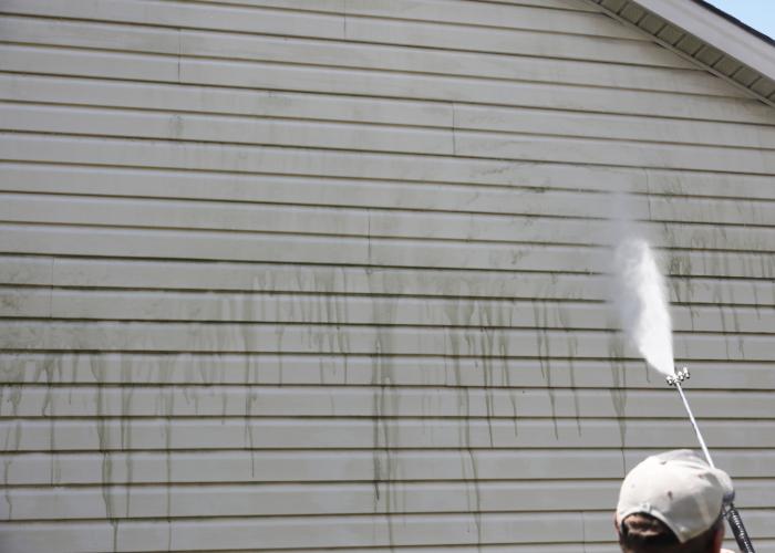 Contractor pressure washing siding in Largo.